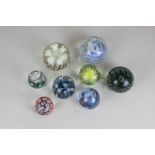 A Whitefriars glass paperweight, a Caithness Mooncrystal paperweight, a millefiori paperweight and