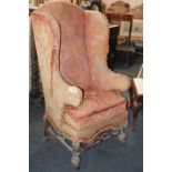 A 19th century wing back armchair on cabriole legs and brass castors (a/f - needs re-