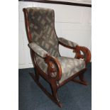 A mahogany framed rocking chair with open arms, upholstered back, seat and arms, on curved rockers