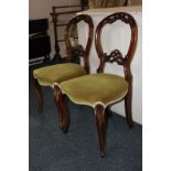 A pair of Victorian mahogany balloon back chairs with green upholstered seats, on cabriole legs