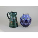 An Elton pottery pinched spout jug in green, blue and brown glaze, with raised floral detail, 19.