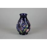 A Moorcroft anemone pattern pottery vase on blue ground, stamped Moorcroft to base, in original box,