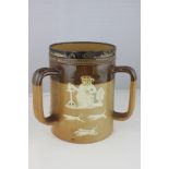 A Royal Doulton silver mounted stoneware three handled mug, decorated with ale drinker and hunting