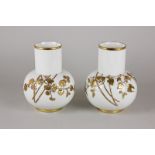 A pair of Royal Worcester porcelain vases with raised gilt leaf and berry decoration, 16cm, (one a/f