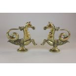 A pair of brass cavallis in the mythical combination of horse, fish and bird, both holding a chain