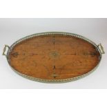 An Edwardian walnut tea tray with brass gallery and handles, inlaid with central floral motif and