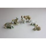 A set of four miniature Wade porcelain dogs together with another similar dog