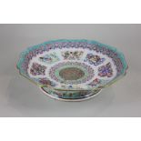 A Chinese famille rose porcelain dish decorated with scroll panels and dragons, on pedestal base,