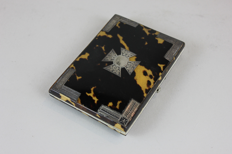 A Victorian tortoiseshell purse with unmarked silver inlay corners and central cross shaped