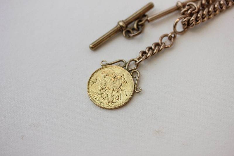 A 9ct gold solid curb link chain with 'T' bar and swivel and hung with an 1892 half sovereign, 33.7g