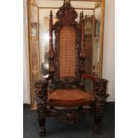 A large oak Carolean style armchair with a large armorial crest above a pierced carved back