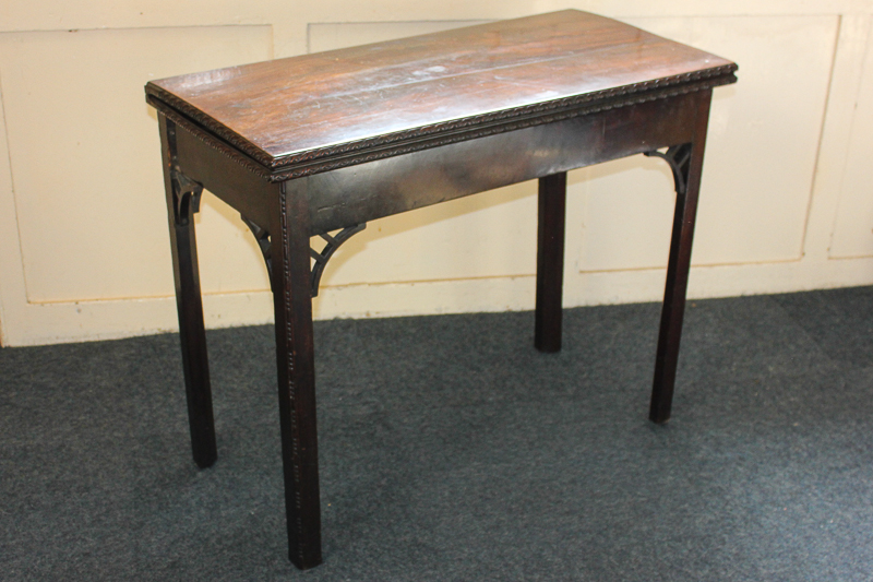 A George III mahogany card table with new baize insert and carved edges, on square chamfered legs,