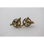 A pair of gold and diamond earrings leaf spray design set with a single diamond screw fittings