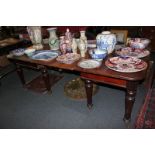 A mahogany D-end extending dining table with turned legs on castors, with two leaves, 214cm fully