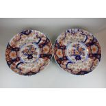 A pair of Japanese Imari porcelain chargers with central floral motif, scalloped edges and seal mark