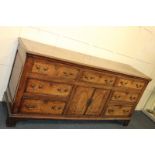 A George III oak dresser base with centre cupboard and seven drawers on bracket feet, 202cm