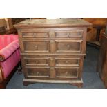 An 18th century oak chest in two sections of four long drawers, alternate narrow and deep, on