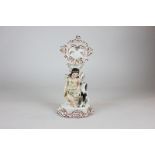 A 19th century Staffordshire pottery model of a girl and a dog seated below a pocket watch stand,