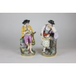 A pair of Italian porcelain figures of a boy playing a pipe and a girl crying over a dead bird, 19cm