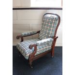 An early 20th century mahogany framed reclining chair with padded seat, back and arms, on turned