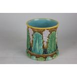 A Majolica jardiniere with purple floral decoration and green foliage on brown ground with turquoise