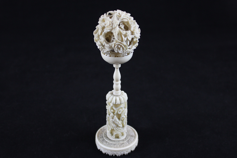 A 19th century Chinese ivory puzzle ball on stand, the ball carved with floral decoration (a/f), the