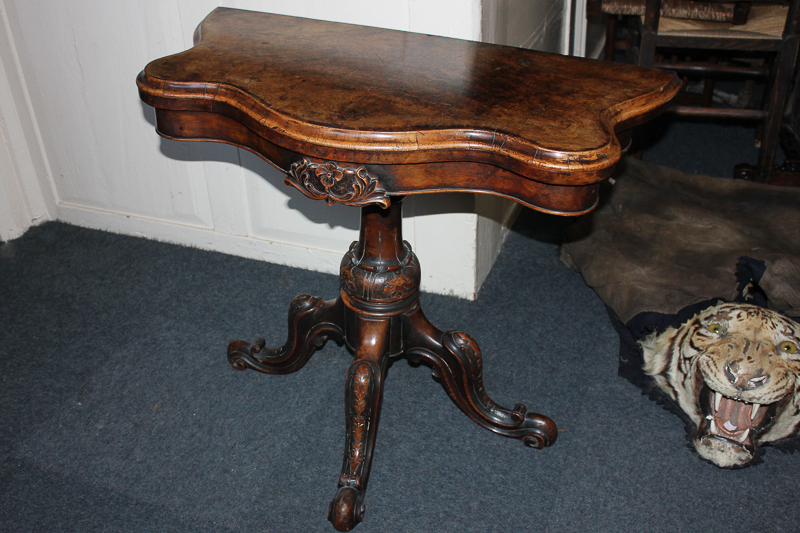 A Victorian walnut serpentine card table on carved baluster support on four scroll legs, 91cm