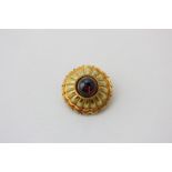 A Victorian gold and cabochon garnet mourning brooch with glazed rear compartment