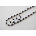 A lapis lazuli bead and cultured pearl necklace on a 9ct gold clasp and a pair of matching earrings