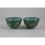 A pair of cloisonne bowls enamelled in bright blue and greens with floral designs, 8cm diameter