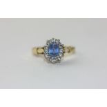 A Ceylon sapphire and diamond cluster ring in 18ct gold