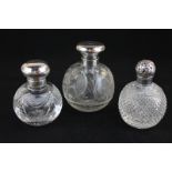 Three silver topped glass travelling scent bottles, various dates and makers