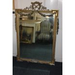 A carved gilt wood and gesso overmantle mirror with floral scrollwork design and ball and dart