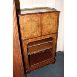 A burr walnut music cabinet with gallery top, with two panel doors enclosing one shelf above a