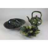 A Dunmore pottery teapot and a Peter Gardner pottery leaf dish, both in mottled green glaze,