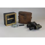 A pair of binoculars in brown leather case (a/f), a magnifying glass, a gilt metal lens in gilt