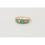 An emerald and diamond five stone ring claw set with round and step cut graduated stones