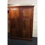 An Edwardian mahogany wardrobe with panelled double doors enclosing hanging compartment and shelves,