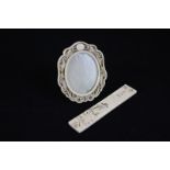 A 19th century Chinese ivory oval picture frame carved with dragons chasing the flaming pearl,