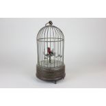 An early 20th century clockwork wind-up singing bird in a cage