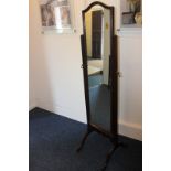 A dark oak framed cheval mirror with shield shaped top, on four curved legs, 47cm