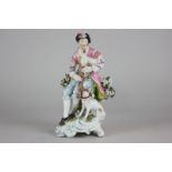 An 18th century Derby porcelain figure of a seated piper and dog, unmarked (a/f), 18cm high