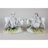 A pair of Staffordshire pottery figures of a man with a cow and a milkmaid with a cow