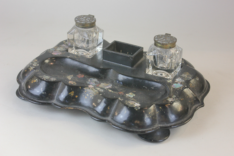 A Victorian papier mache desk stand with mother of pearl inlay, with a pair of glass inkwells