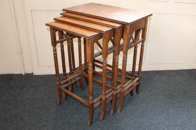 A nest of four oak Arts and Crafts side tables with slender turned legs, 60cm