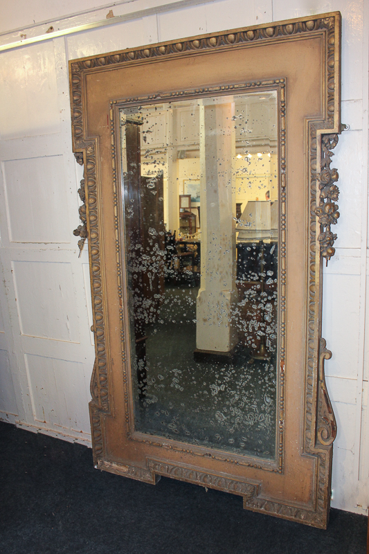 A large carved gilt wood and gesso mirror with egg and dart border and floral swag either side,