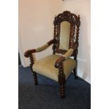 A carved oak Jacobean style armchair with upholstered back, arms and seat, with turned legs on