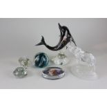 A Bermuda glass dolphin ornament, a clear glass elephant ornament and four paperweights