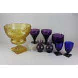 An amber glass fruit bowl on stand, a pair of blue glass goblets, a pair of amethyst glass vases,