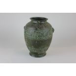 A Chinese bronze vase decorated with geometric pattern banding and raised ram head lugs, 23cm high
